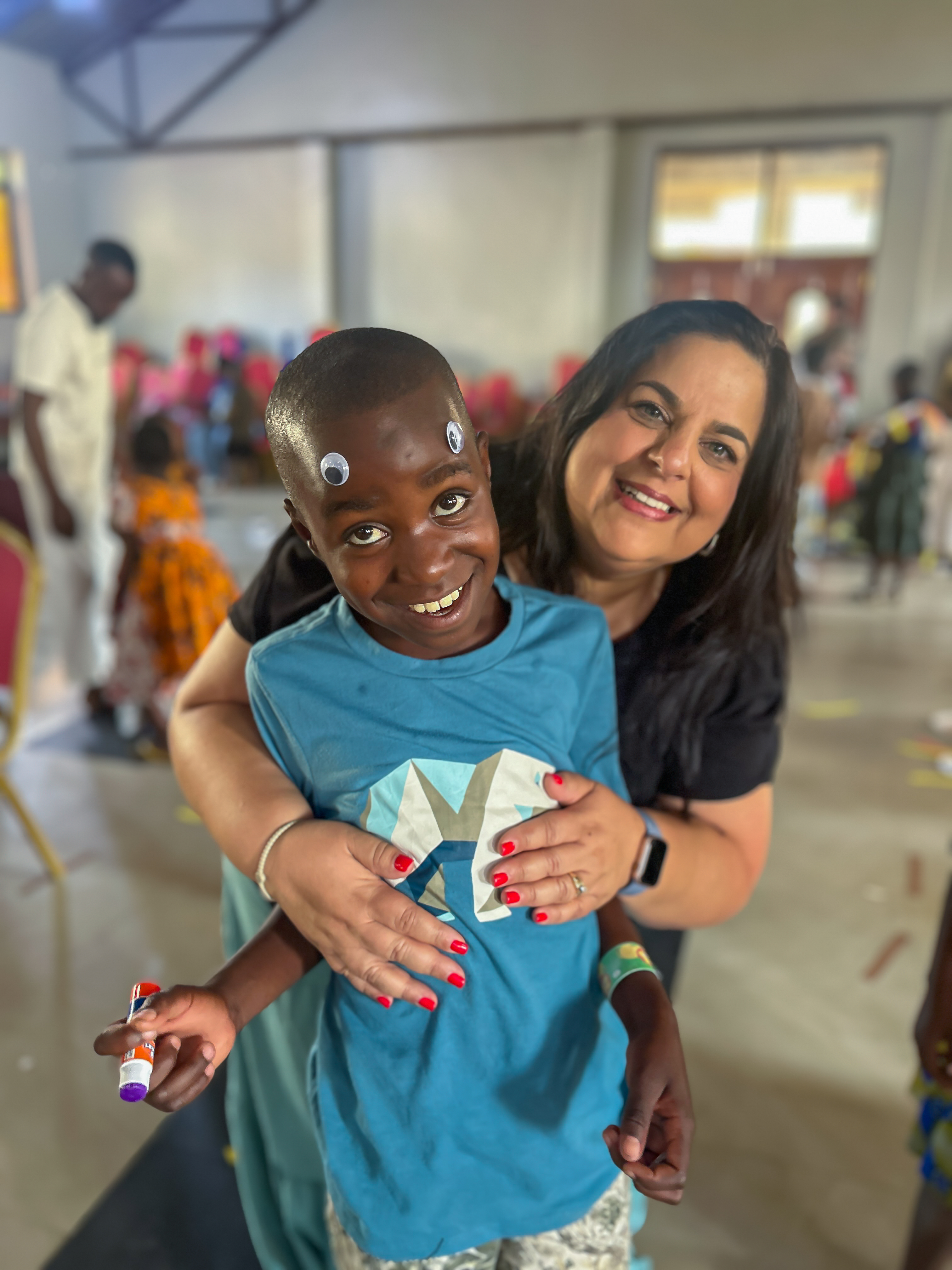 Monica smiling with Tanzanian children at VBS